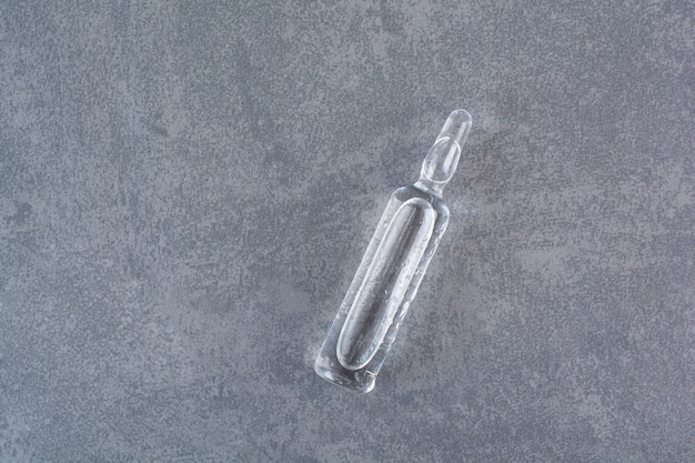 Free photo transparent medical ampoule on marble table.