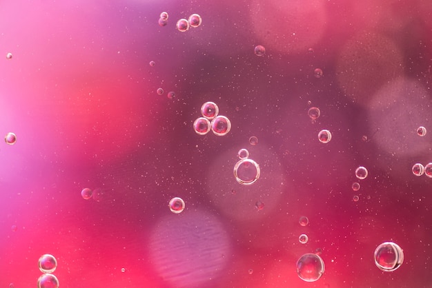 Transparent oil bubbles on burgundy background