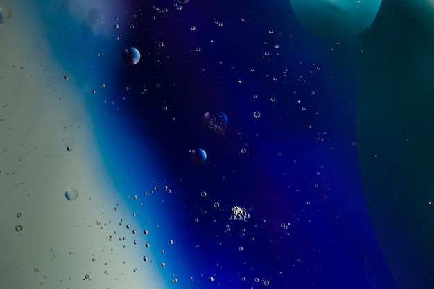 Прозрачные маслянистые пузырьки на яркой копии космического водянистого фона