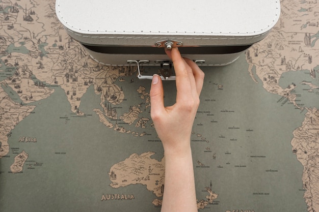 Travel background with hand opening a suitcase