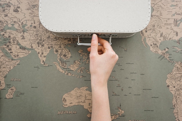 Travel background with hand next to a suitcase