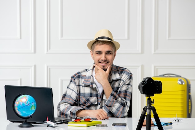 Бесплатное фото Блогер-путешественник, красивый молодой парень, записывающий видеоблог о путешествии на камеру с желтым багажом в восторге