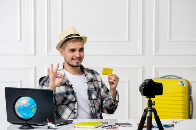 Travel blogger recording trip vlog on camera young handsome guy in straw hat very happy