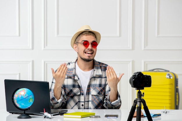 Travel blogger in straw hat young handsome guy recording trip vlog on camera inviting to join him