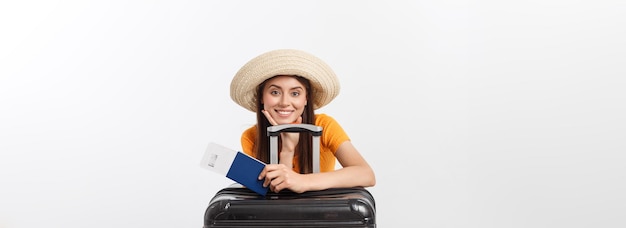 흰색으로 격리된 여권과 수하물을 들고 있는 예쁜 젊은 여성의 여행 컨셉 스튜디오 초상화