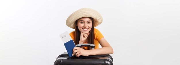 パスポートと白で隔離の荷物を保持しているかなり若い女性の旅行コンセプト スタジオ ポートレート