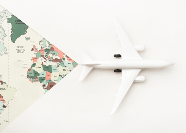 世界地図とおもちゃの飛行機の旅行の概念