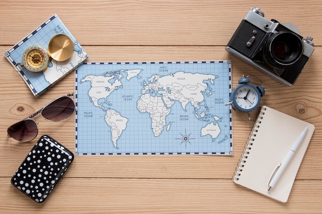 Travel items on wooden background top view