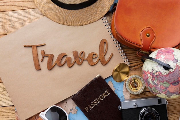 Travel items on wooden background top view