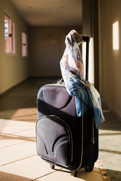 日光の下でスカーフ付き旅行荷物