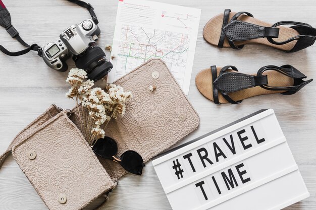 Travel and time text with female accessories on the wooden desk