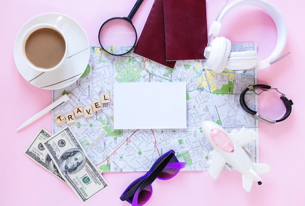 Foto gratuita accessori del viaggiatore e tazza di tè su fondo rosa