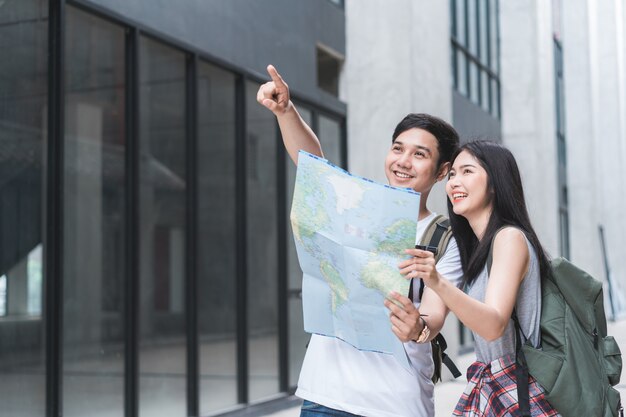 Направление азиатской пары путешественника на карте местоположения в Пекине, Китай