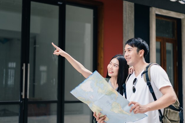 Free Photo traveler asian couple direction on location map in beijing, china