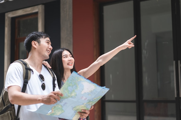 Free photo traveler asian couple direction on location map in beijing, china