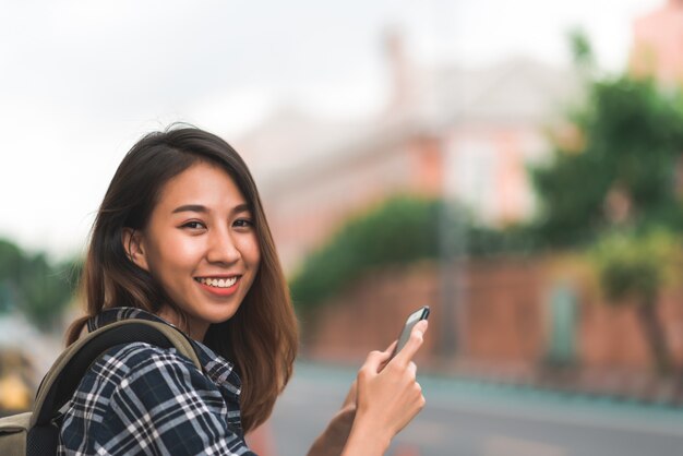 Traveler backpacker Asian woman blogger spending holiday trip at amazing landmark enjoy her journey 