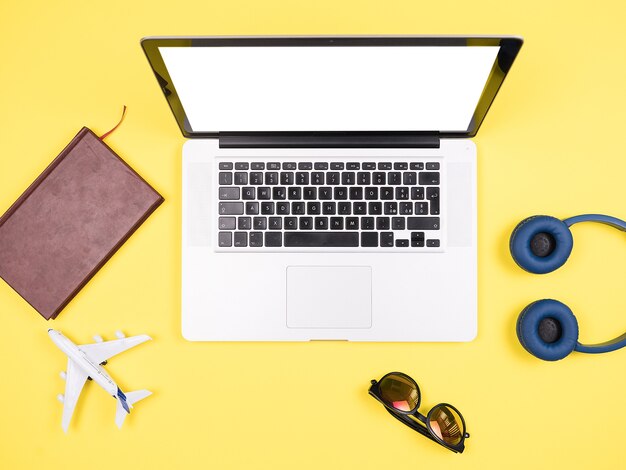 Traveler businessman top view yellow desk concept image,sunglasses, headpphones, pot of grass