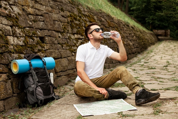 Traveler consulting map while hydrating