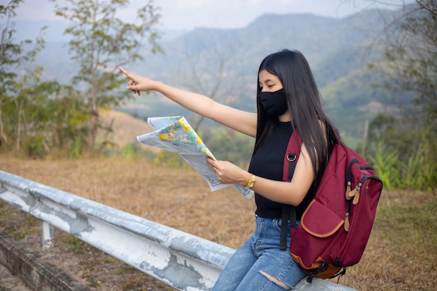 Traveler girl searching right direction on map
