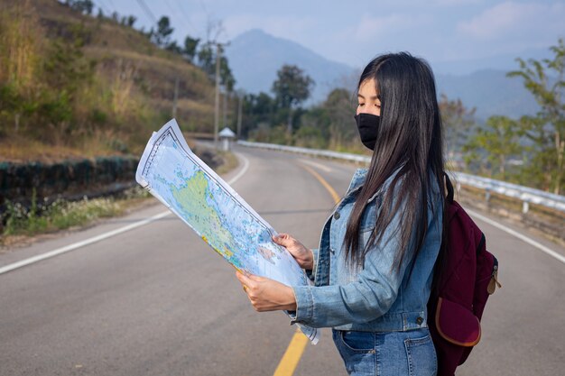 지도에서 올바른 방향으로 검색하는 여행자 소녀