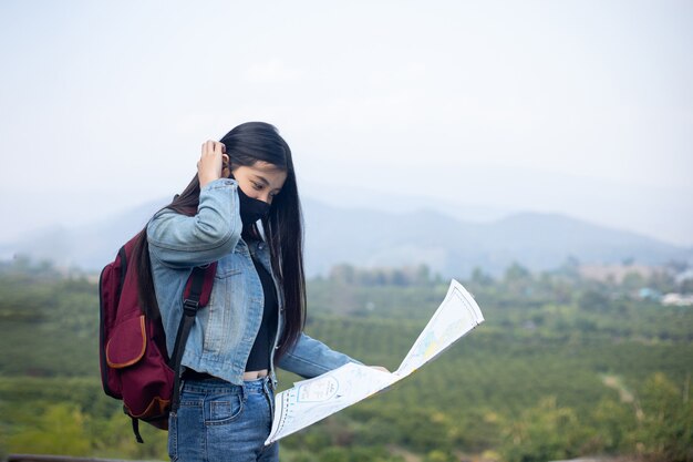 地図上で正しい方向を探す旅行者の女の子