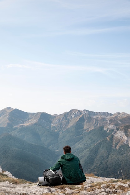 traveler hiking on mountains while having his essentials in a backpack