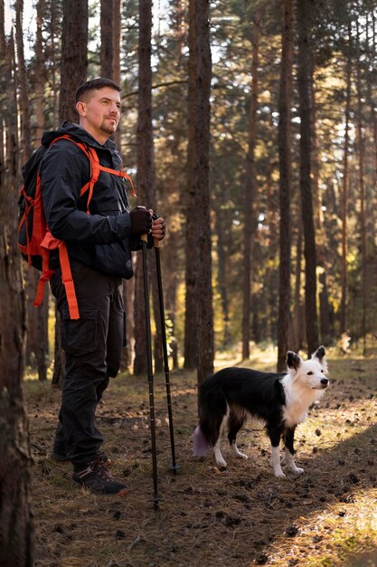 Traveler and his dog walking in the woods