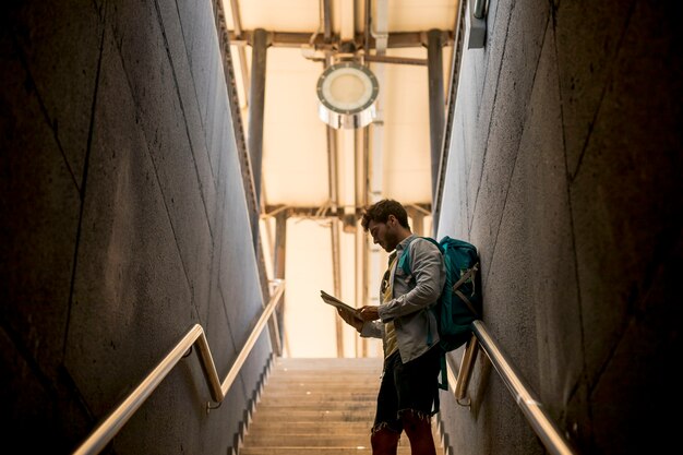 Traveler looking at map on stairs