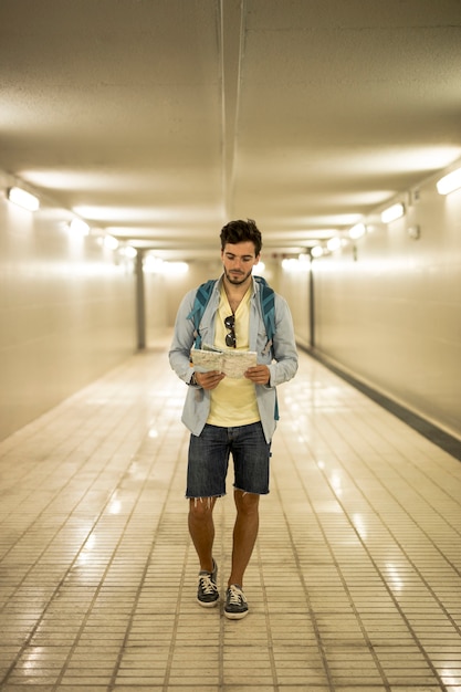 Free photo traveler looking at map in underpass