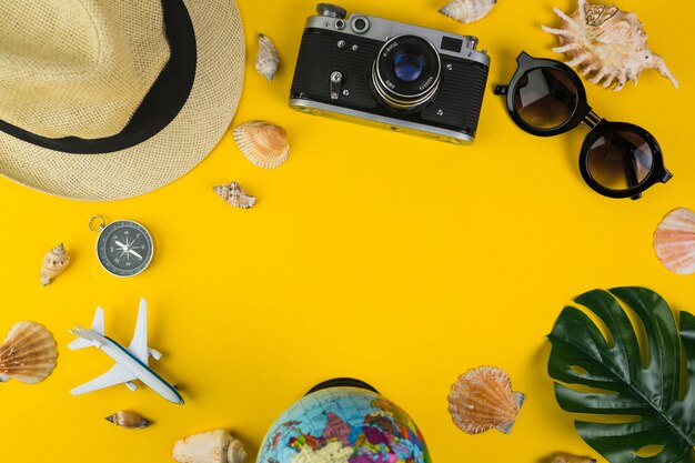 Traveler's equipments with seashell on yellow background