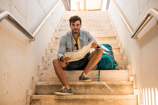 Traveler sitting on stairs looking at camera