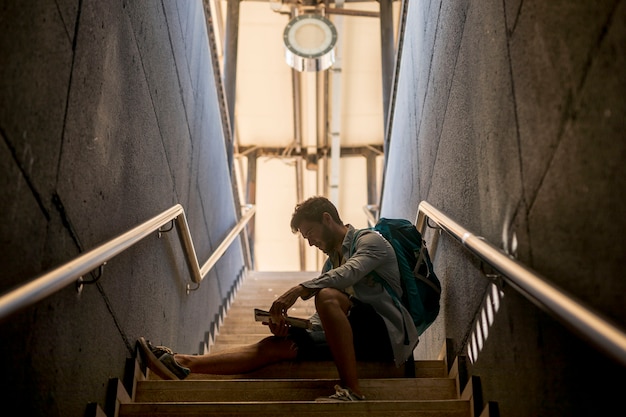 Traveler sitting on stairs at train station