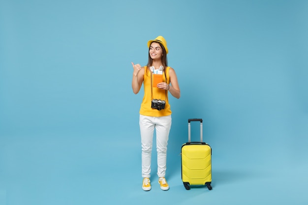 파란색에 티켓 가방 카메라를 들고 노란색 여름 캐주얼 옷 모자에 여행자 관광 여자 프리미엄 사진