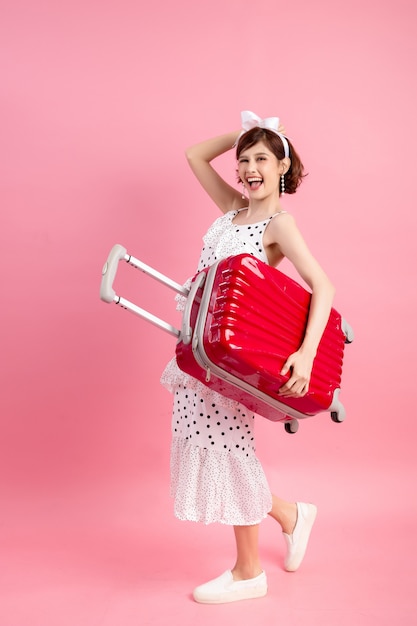 Free photo traveler tourist woman in summer casual clothes with travel suitcase isolated on pink