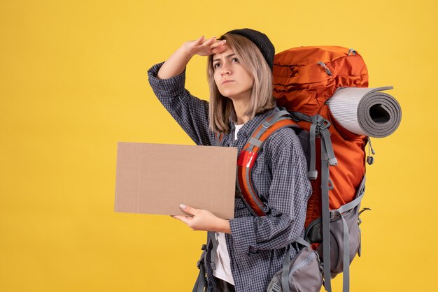 traveler woman with backpack holding cardboard