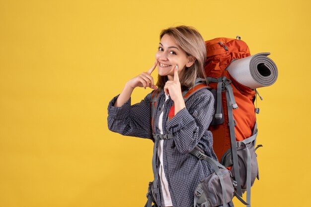 Donna viaggiatrice con zaino rosso sorridente