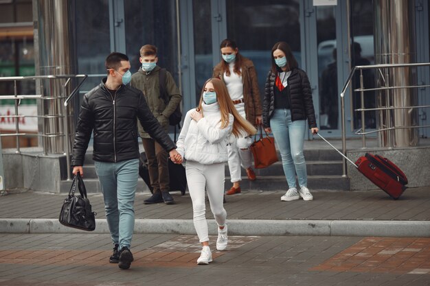 공항을 떠나는 여행자는 보호 마스크를 착용하고 있습니다