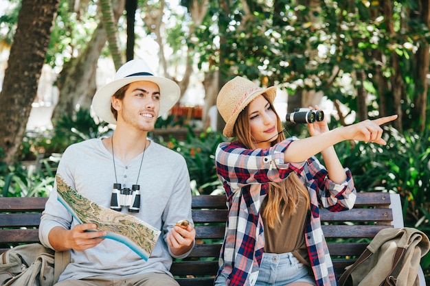 Free photo travelers, map and binoculars in the park