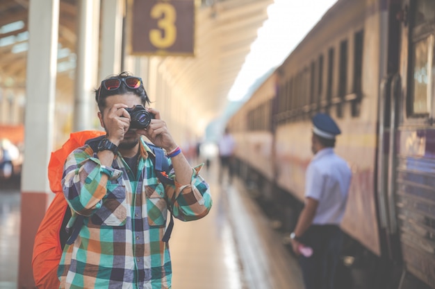 電車を待っている間旅行者はカップルの写真を撮る。