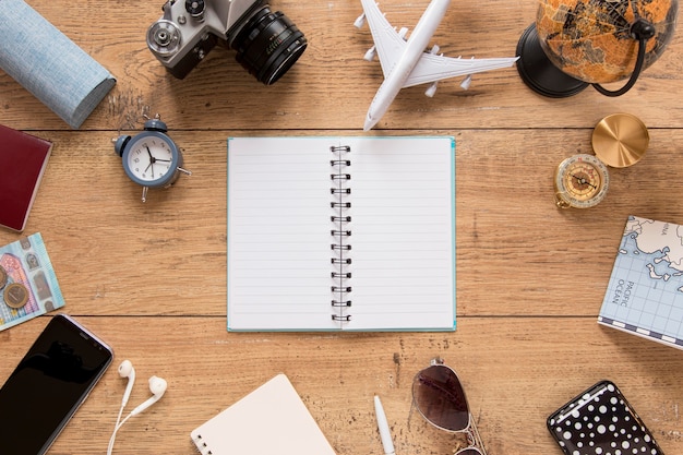 Traveling items on wooden background top view