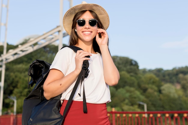 Foto gratuita donna in viaggio con zaino utilizzando i suoi auricolari