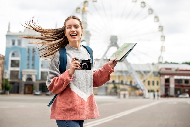 Foto gratuita viaggiatore in città e ruota panoramica dietro