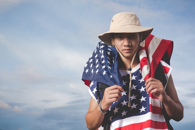 Free photo traveller holding a flag in front of sky view