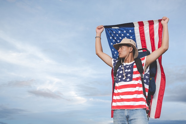 Free photo traveller raise a flag in front of sky view