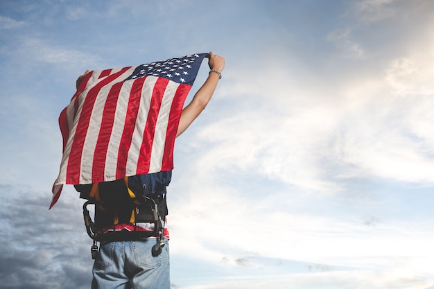 Путешественник поднимает флаг перед видом на небо