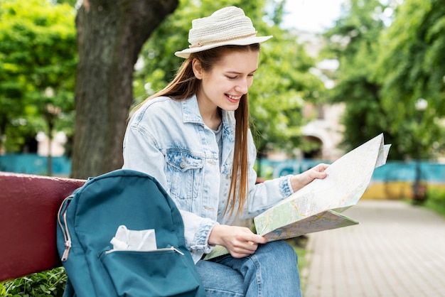 医療マスクと座っている地図を身に着けている旅行者