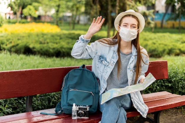 Traveller wearing medical mask waving