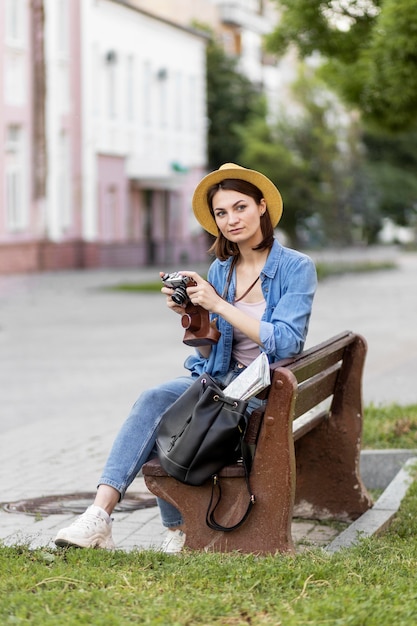 Traveller with hat holding camera on holiday