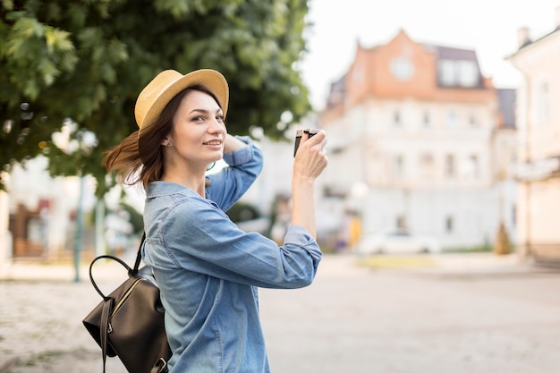 屋外で写真を撮る帽子の旅行者