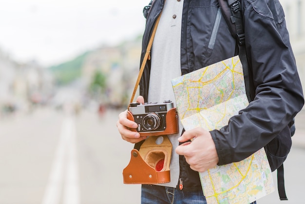 Путешественник с картой и камерой на улице